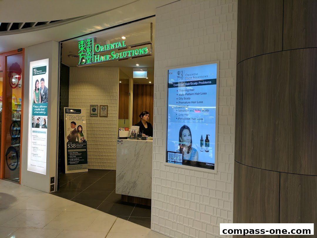 The entrance to Oriental Hair Solutions, showcasing their services and a staff member at the counter.