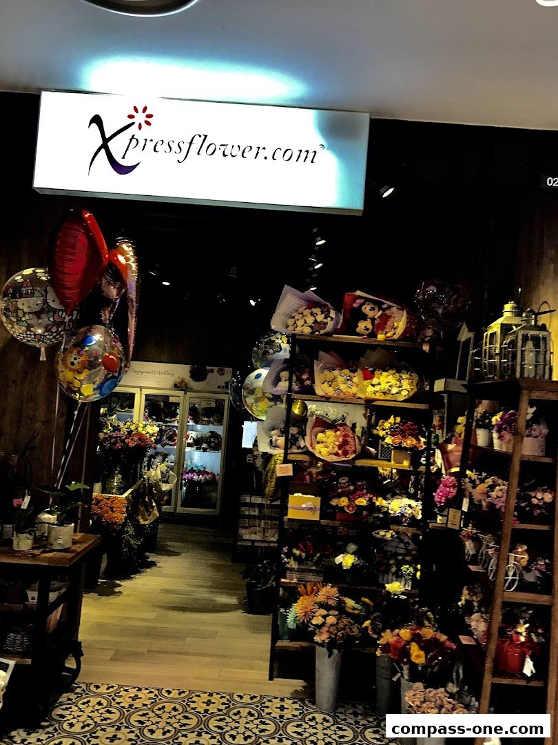 Interior view of a flower shop with bouquets, balloons, and floral displays.