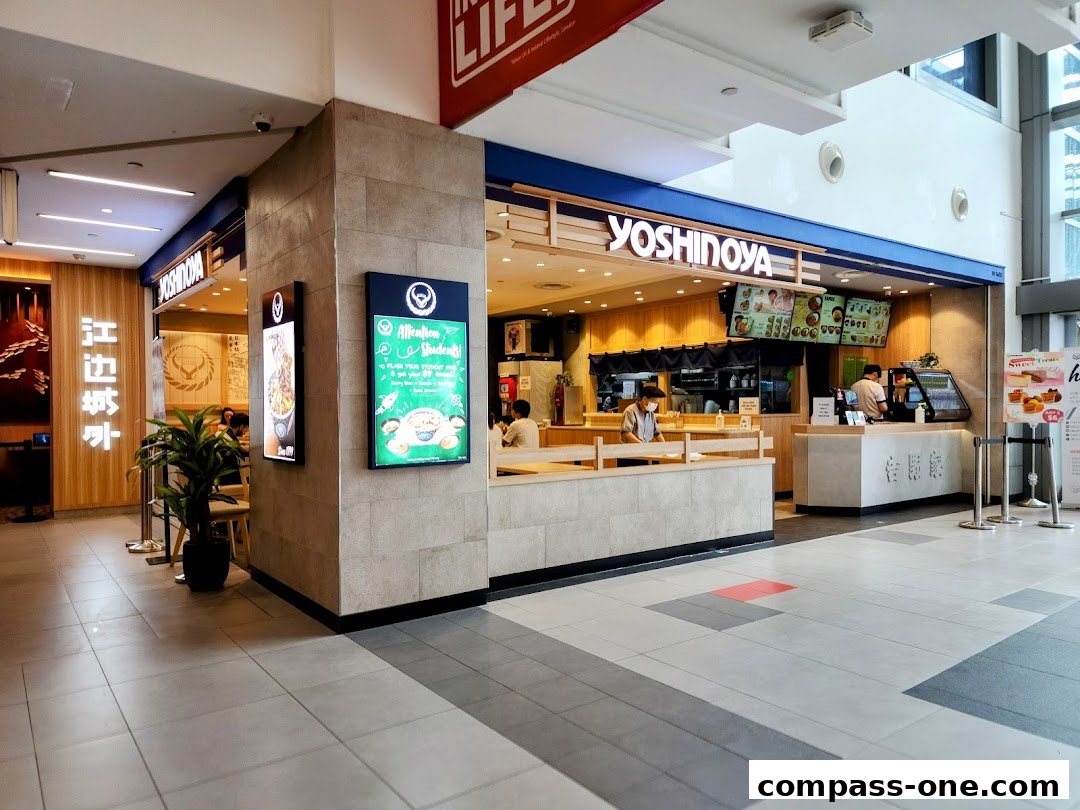 The Yoshinoya restaurant entrance with a counter, seating area, and menu displays.