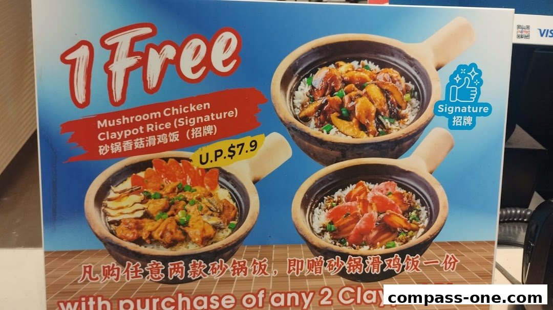 A promotional sign for Kopitiam offering a free Mushroom Chicken Claypot Rice with purchase of two claypot rice dishes.