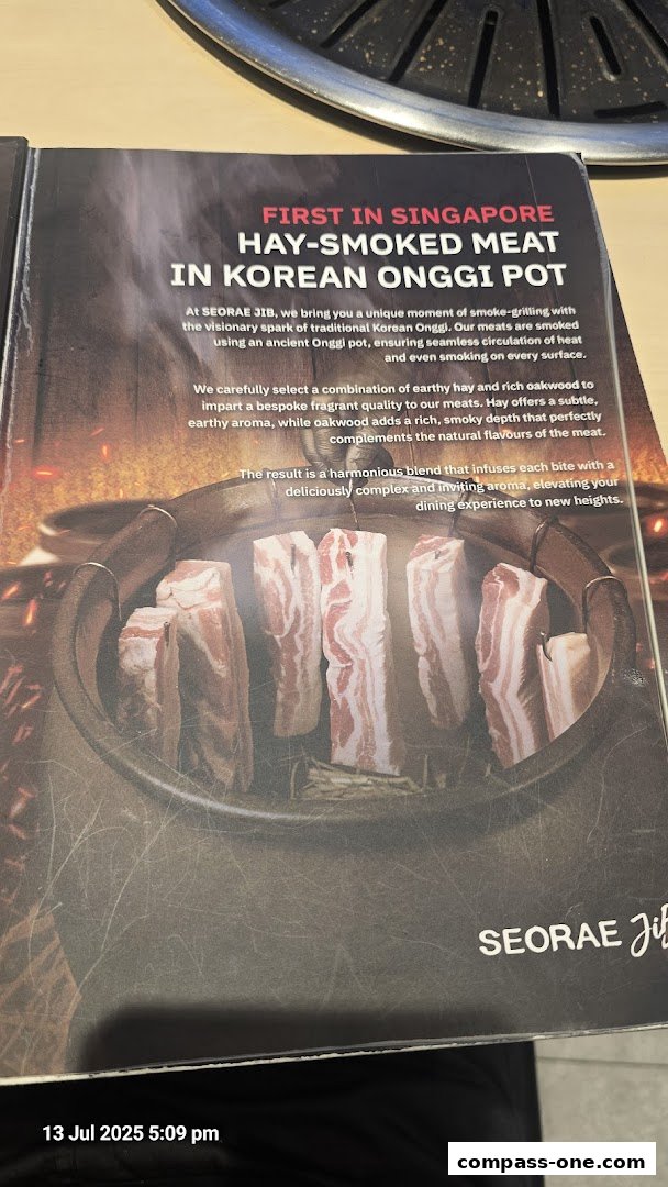 A menu page showcasing hay-smoked meat in a Korean Onggi pot at SEORAE JIB.