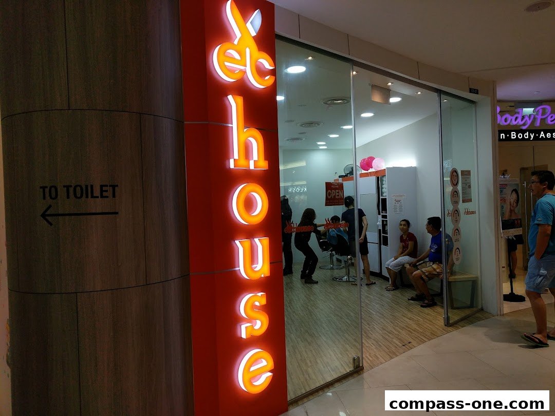 The brightly lit entrance of EC House All Range Cuts hair salon with people inside.