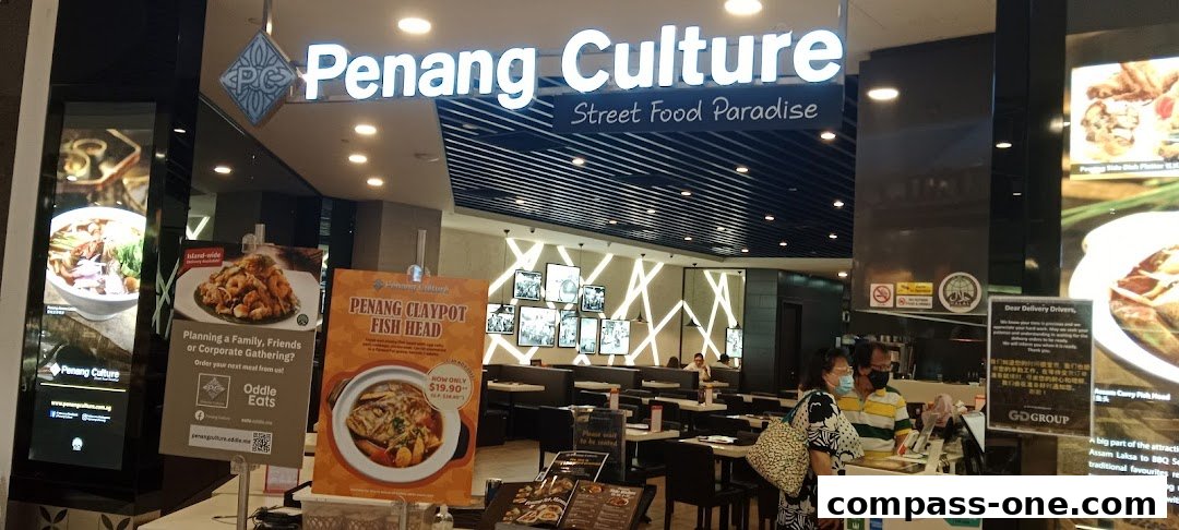 The entrance of Penang Culture restaurant, a street food paradise, with promotional posters and indoor seating visible.