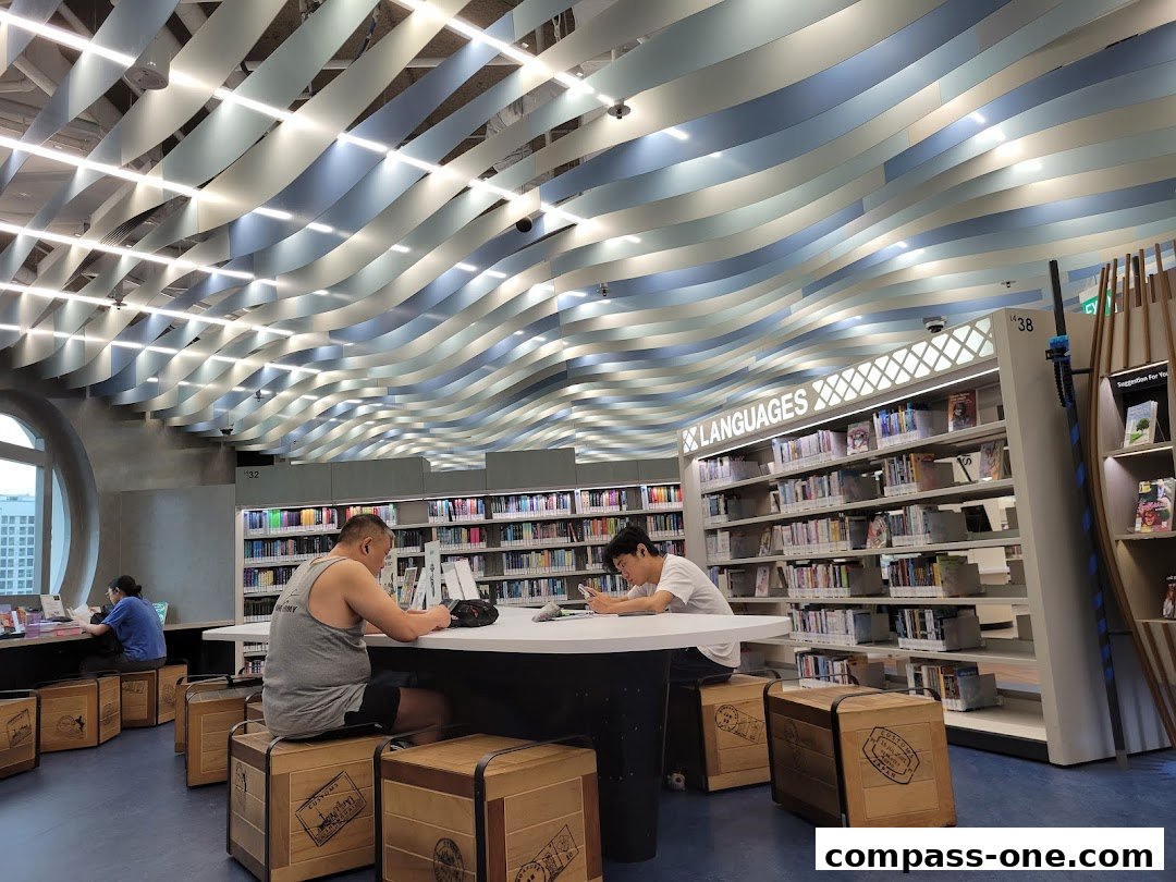 People studying at tables in a modern library with wavy ceiling.