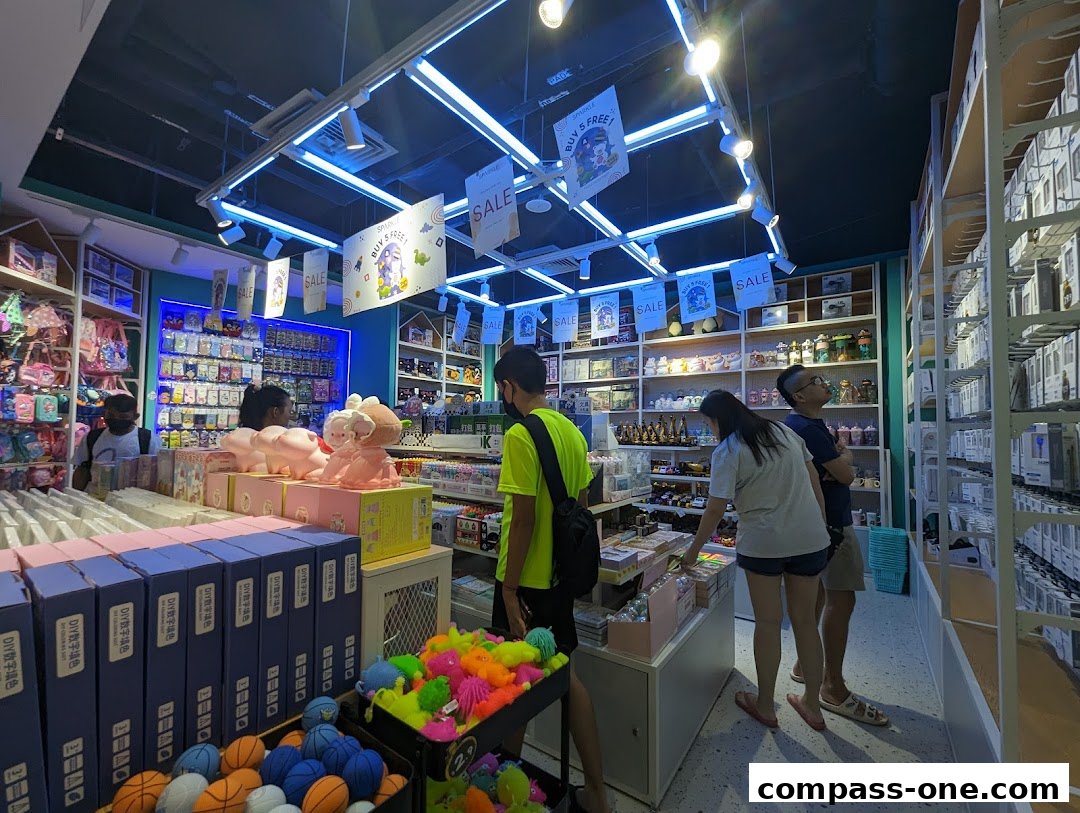 Customers browsing a brightly lit retail store filled with various merchandise and promotional signs.