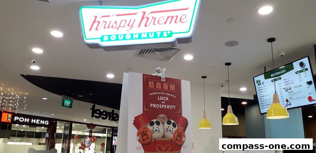 Krispy Kreme shop interior with a neon sign, a beverage menu, and festive decorations.