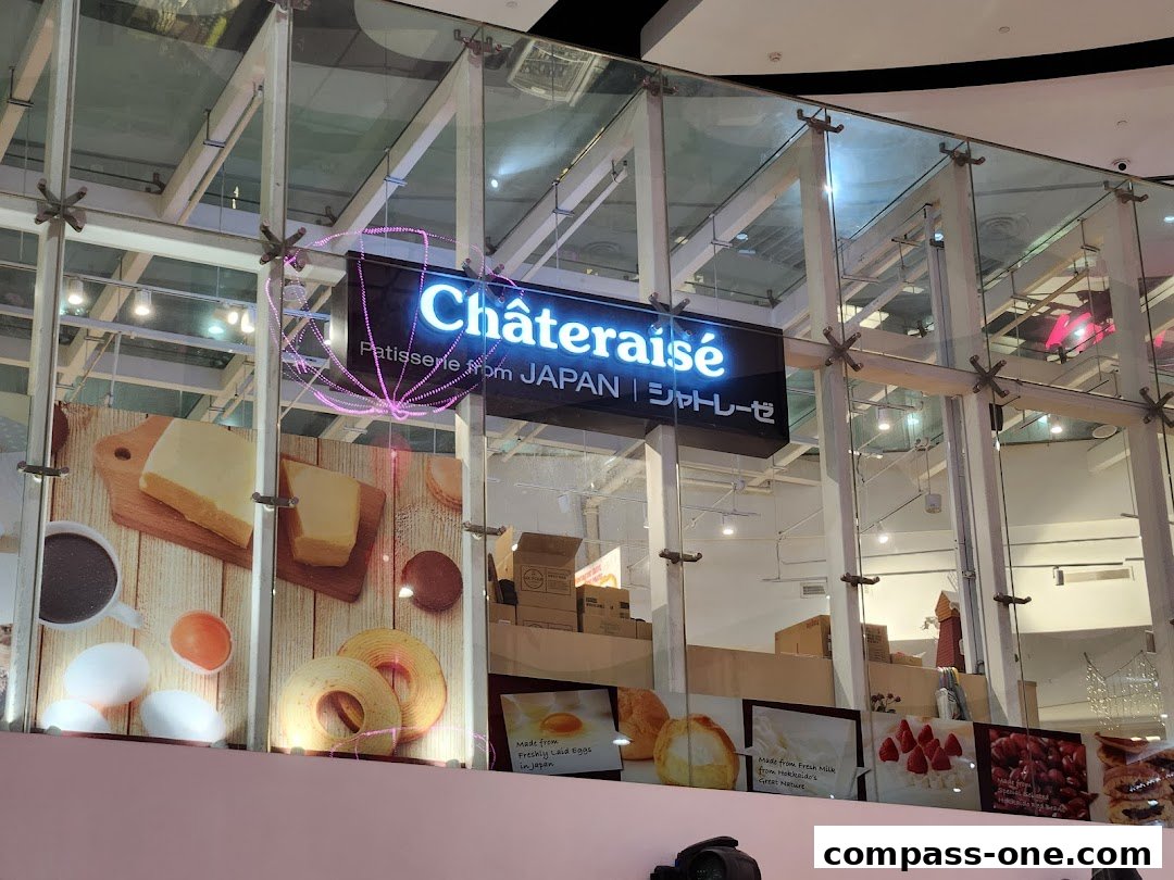 The exterior of a Châteraisé patisserie shop with a neon sign and product displays.