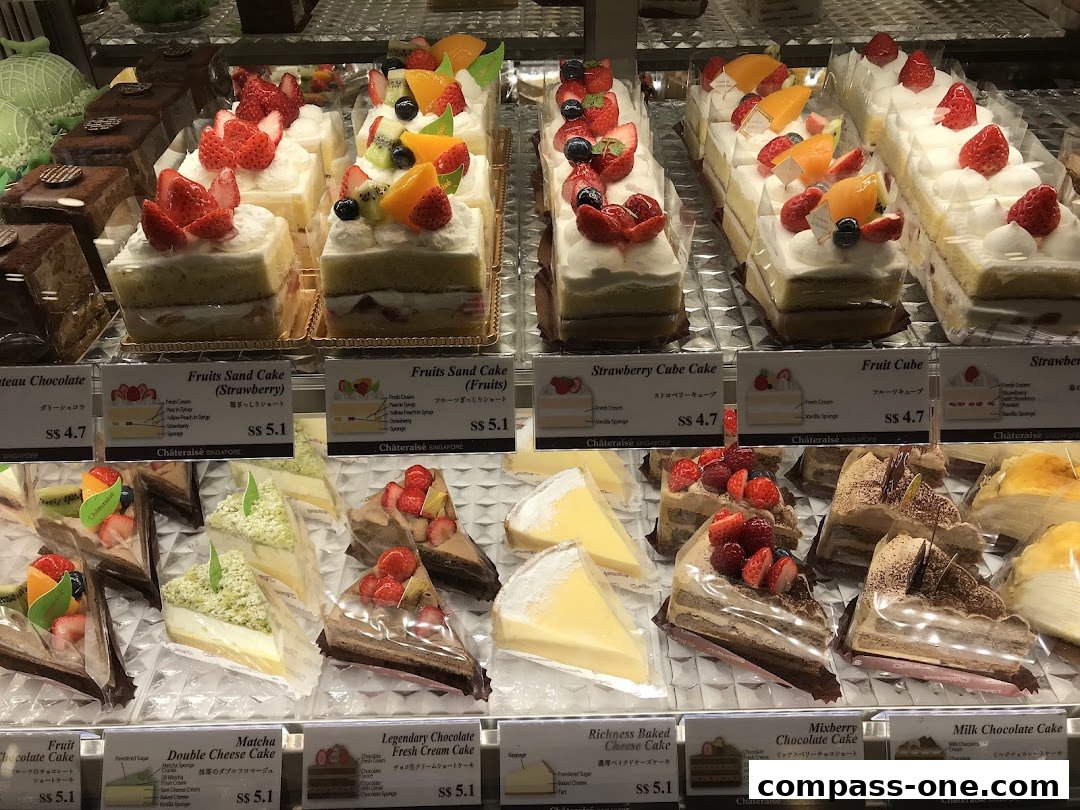 A display of various cakes and pastries with price labels at Châteraisé.