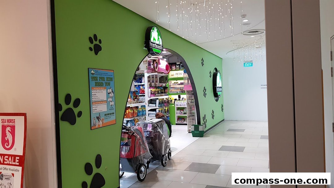 The entrance to a brightly lit pet store with shelves stocked with pet supplies.