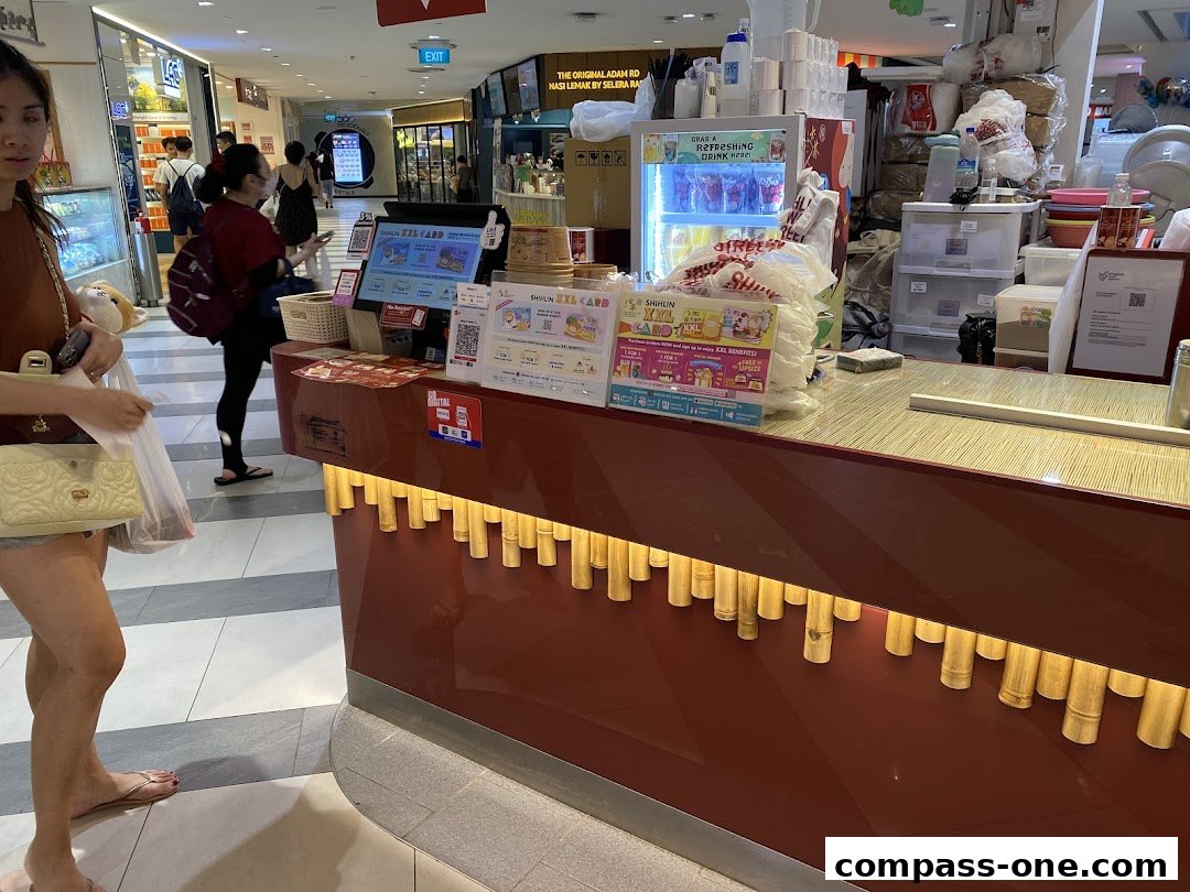 A counter at Shihlin Taiwan Street Snacks with promotional materials and drinks in a cooler.