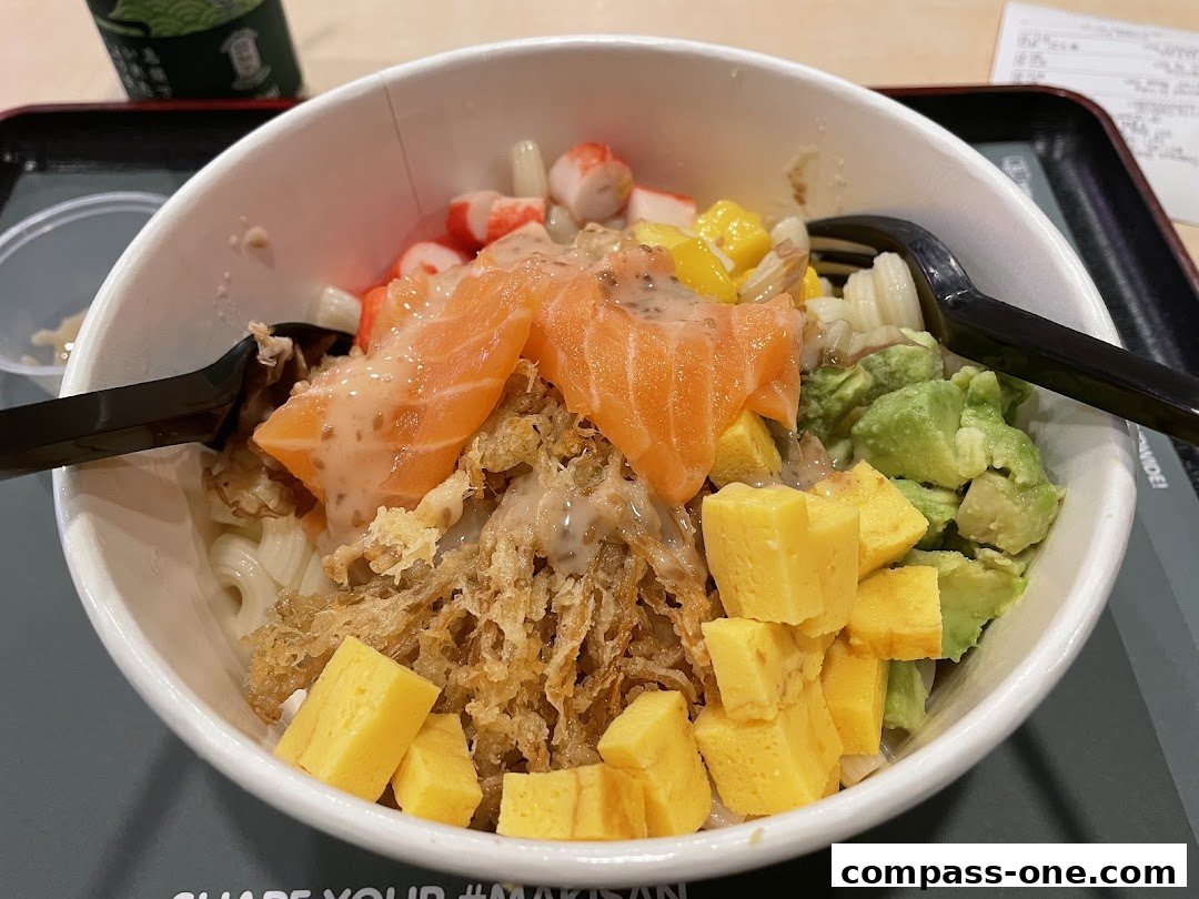 A close-up of a poke bowl with salmon, avocado, imitation crab, and egg.