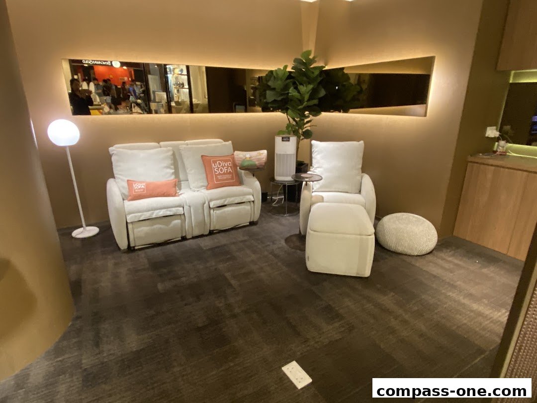 A modern living room setup with a white sofa, armchair, ottoman, and floor lamp.