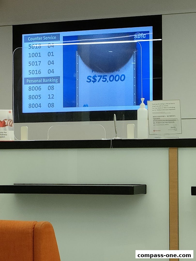 A digital display shows queue numbers for counter service and personal banking at OCBC Bank.