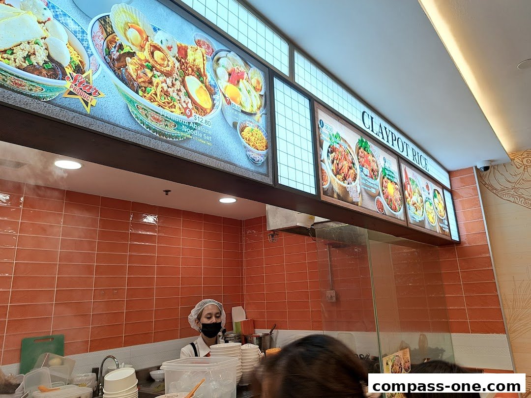 A brightly lit menu board showcasing various noodle and claypot rice dishes at Encik Tan.