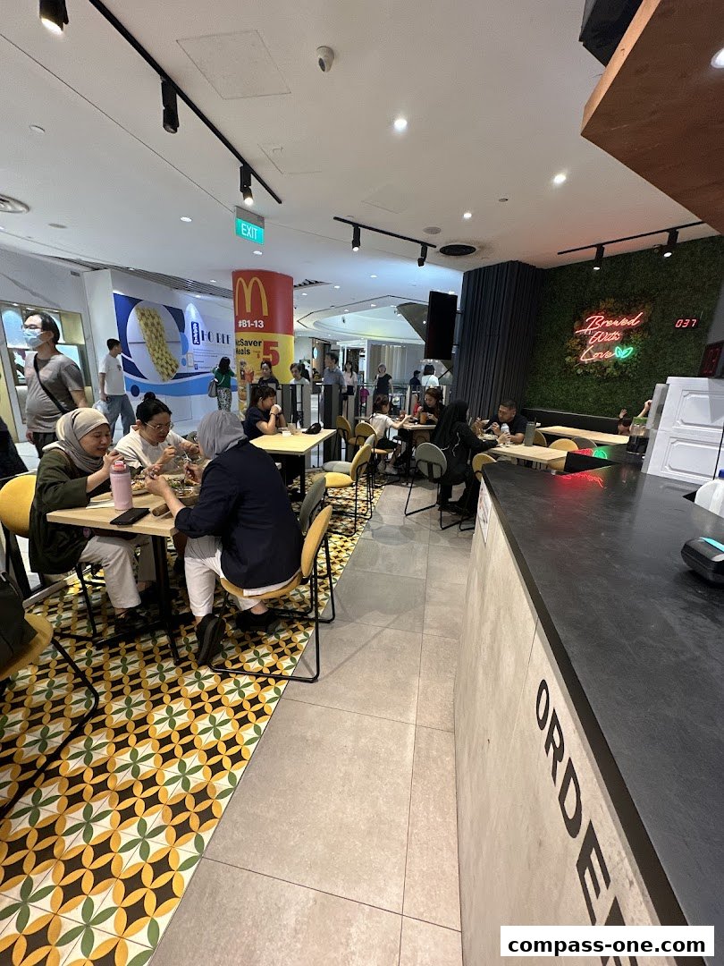 People dining inside a brightly lit restaurant with modern decor and a green wall.