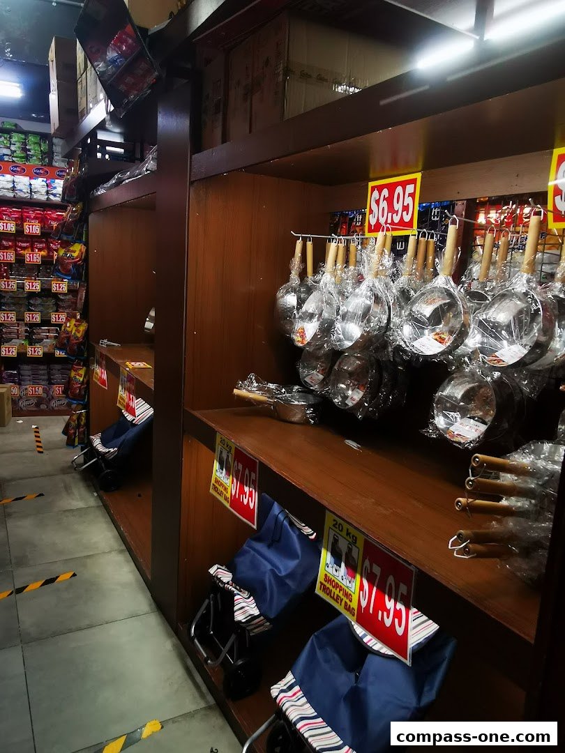 A retail store aisle displaying kitchenware and shopping trolley bags with price tags.