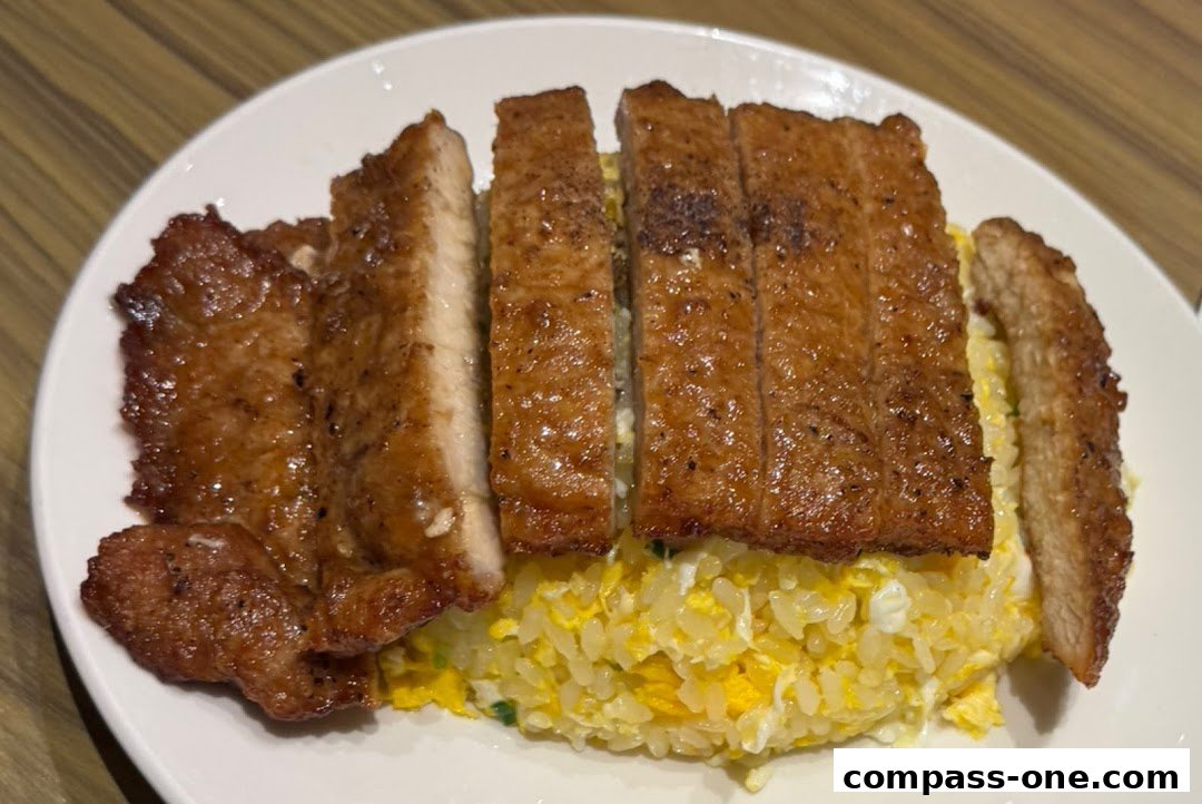 A plate of sliced pork chop served with fried rice.