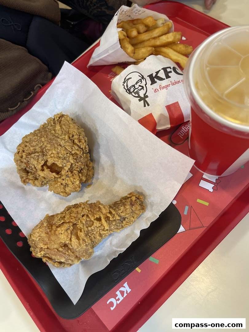 A tray of KFC fried chicken, fries, and a drink on a red tray.