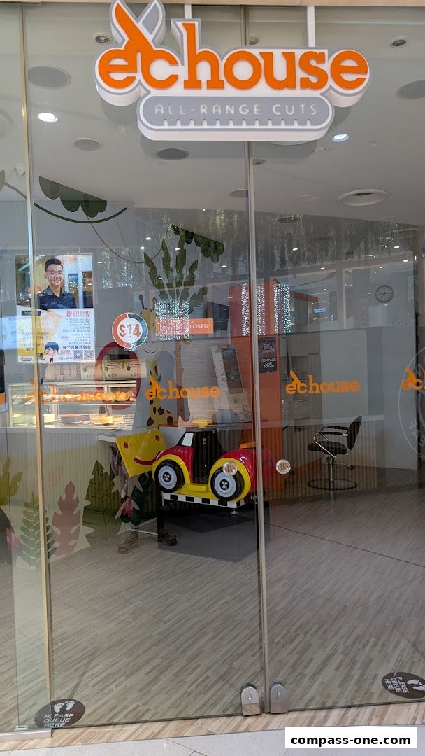 The entrance to EC House All Range Cuts, a hair salon with a playful design and a children's ride-on toy.