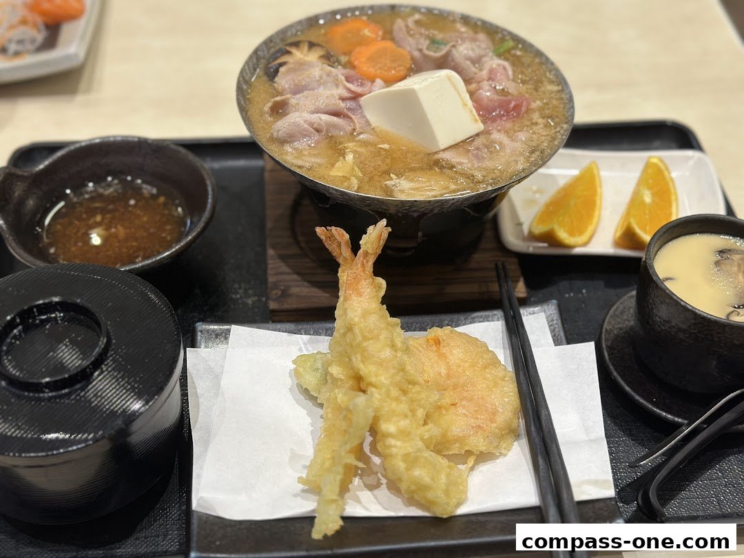 A delicious Japanese meal featuring tempura, a hot pot dish, and a side of soup.