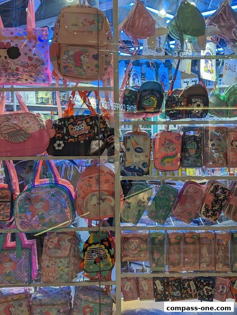 A display of colorful backpacks, bags, and pencil cases with unicorn and cartoon designs.