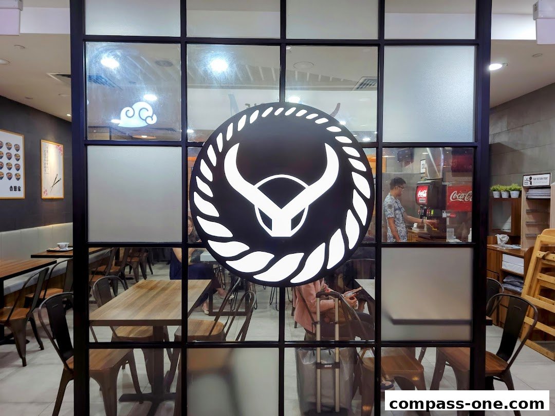 View of Yoshinoya restaurant interior through a glass partition with the Yoshinoya logo.
