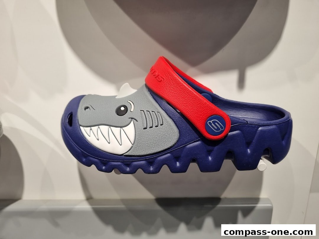 A blue and red Skechers clog designed to look like a shark with a smiling face.
