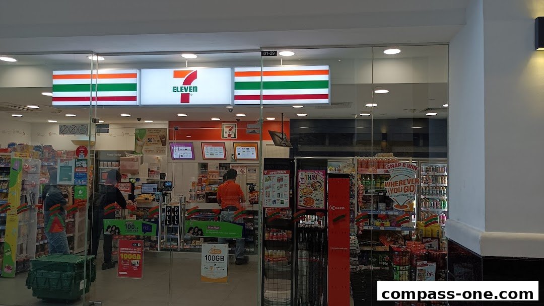 The exterior of a 7-Eleven convenience store with its iconic signage and displays visible.