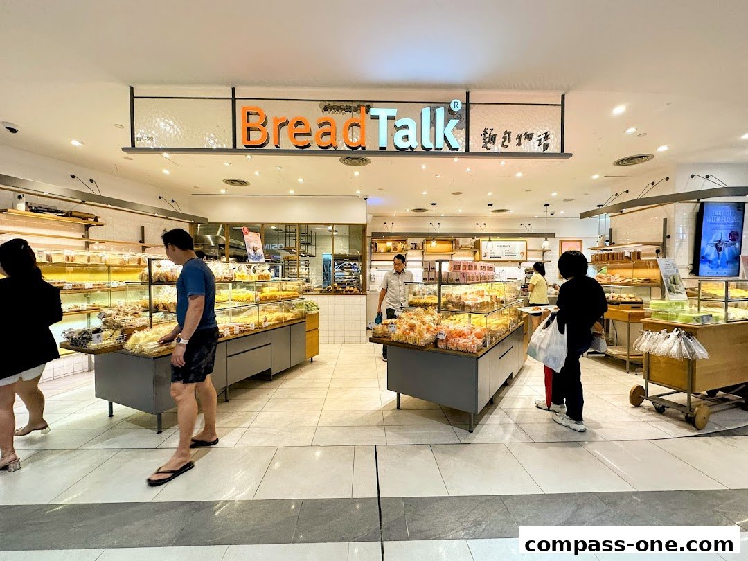 Interior of a BreadTalk bakery with customers browsing a wide selection of fresh bread and pastries.