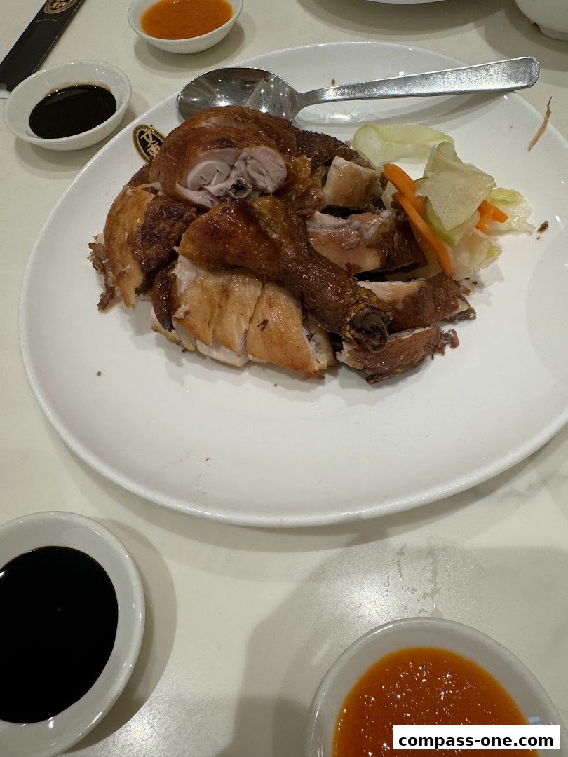 A plate of delicious roasted chicken with dipping sauces and pickled vegetables.