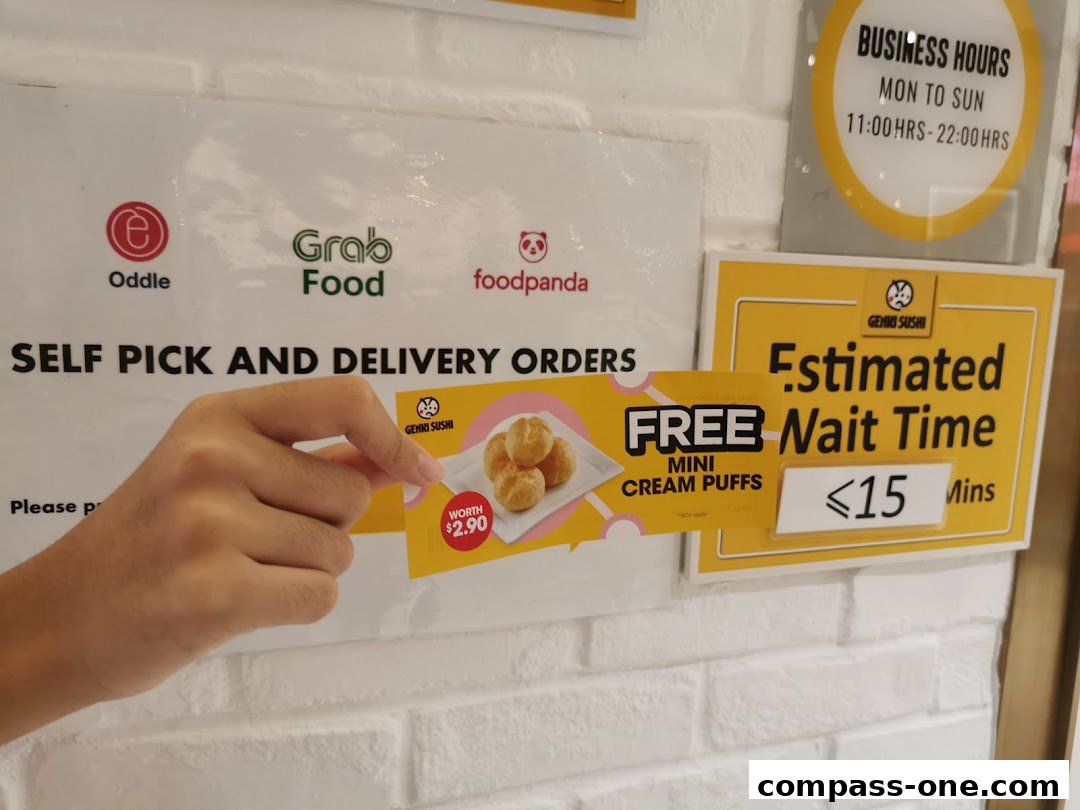 A hand holds a coupon for free mini cream puffs at Genki Sushi, with delivery service logos and wait time information visible.