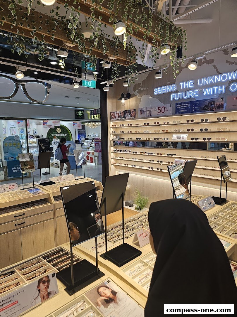 Interior of an eyewear shop with displays of glasses and a customer browsing.