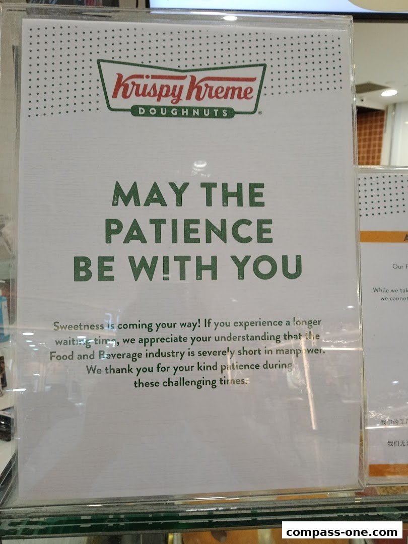 A sign at Krispy Kreme Doughnuts apologizes for potential wait times due to staff shortages.