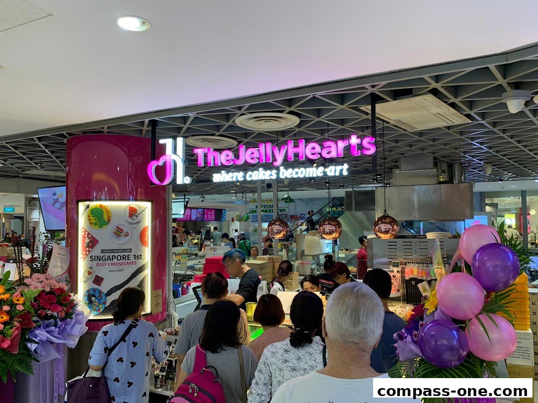 A busy dessert shop with a prominent neon sign and customers queuing.