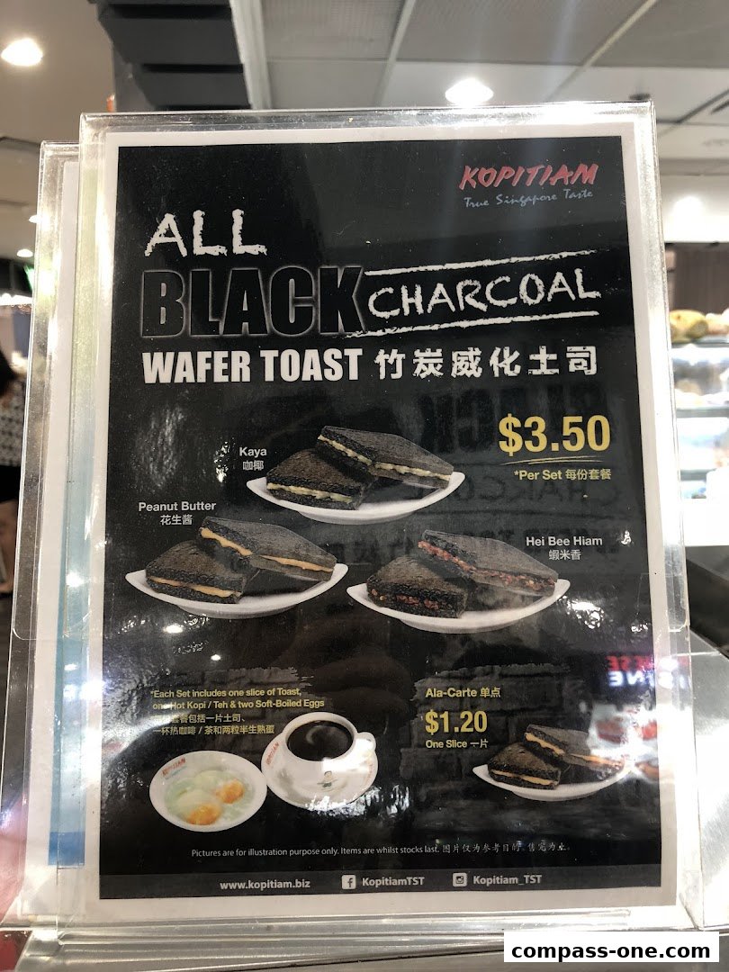 A menu board showcasing Kopitiam's All Black Charcoal Wafer Toast with various fillings.
