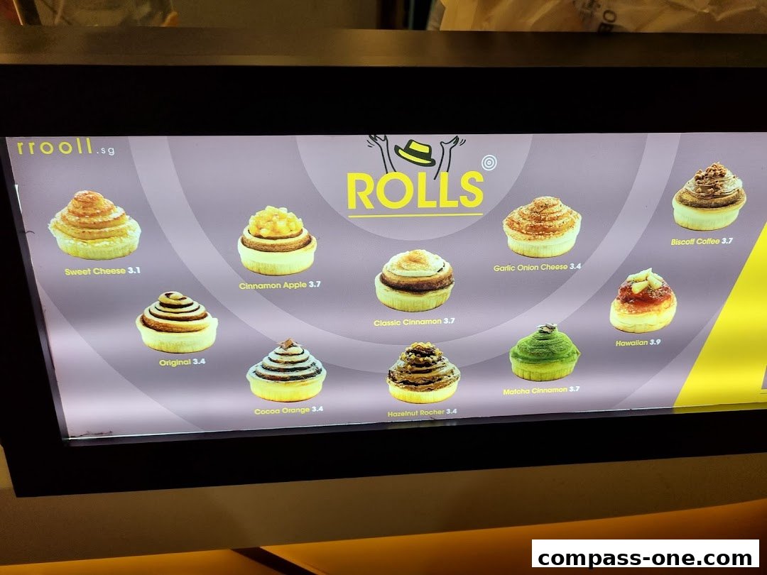A display of various flavored cinnamon rolls with their names and prices.