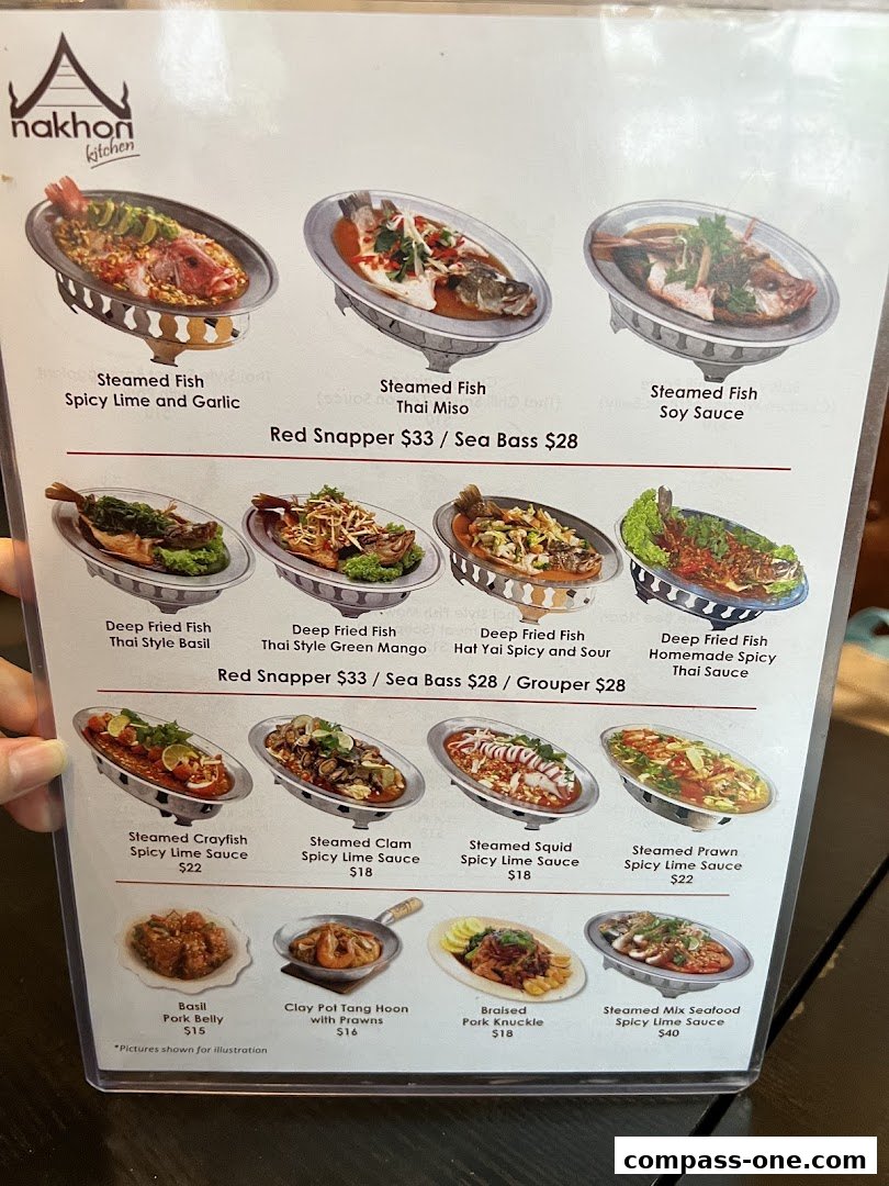 A menu from Nakhon Kitchen featuring various steamed and fried fish dishes, seafood, and pork belly.