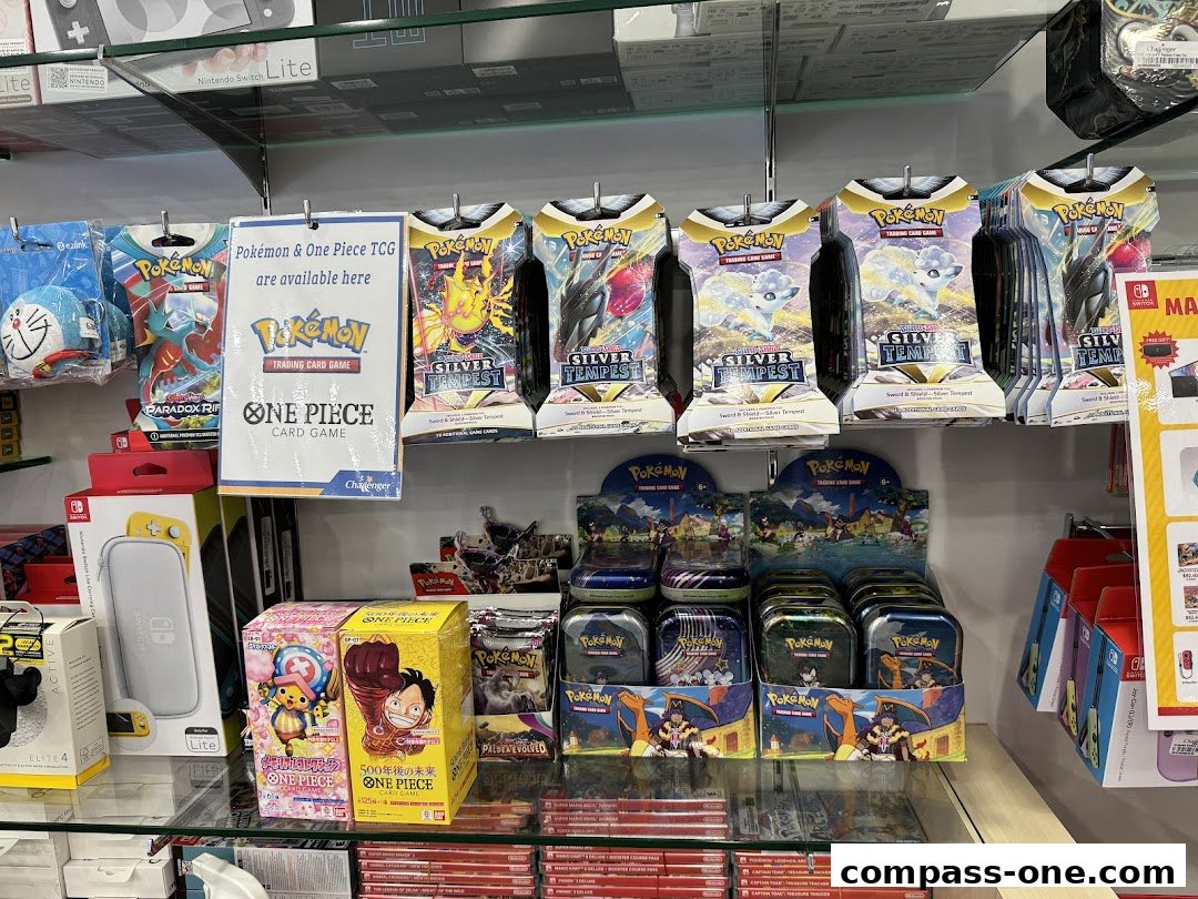 Shelves stocked with Pokémon and One Piece trading card game products, including booster packs and tins.