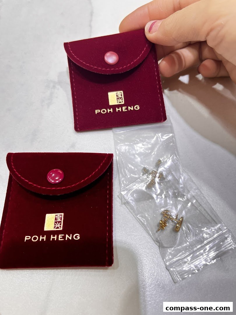 Two red velvet pouches with Poh Heng Jewellery logo and a plastic bag of gold earrings.