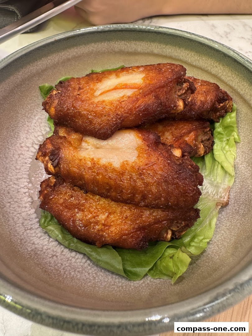 A close-up shot of crispy fried chicken wings served on a bed of lettuce.