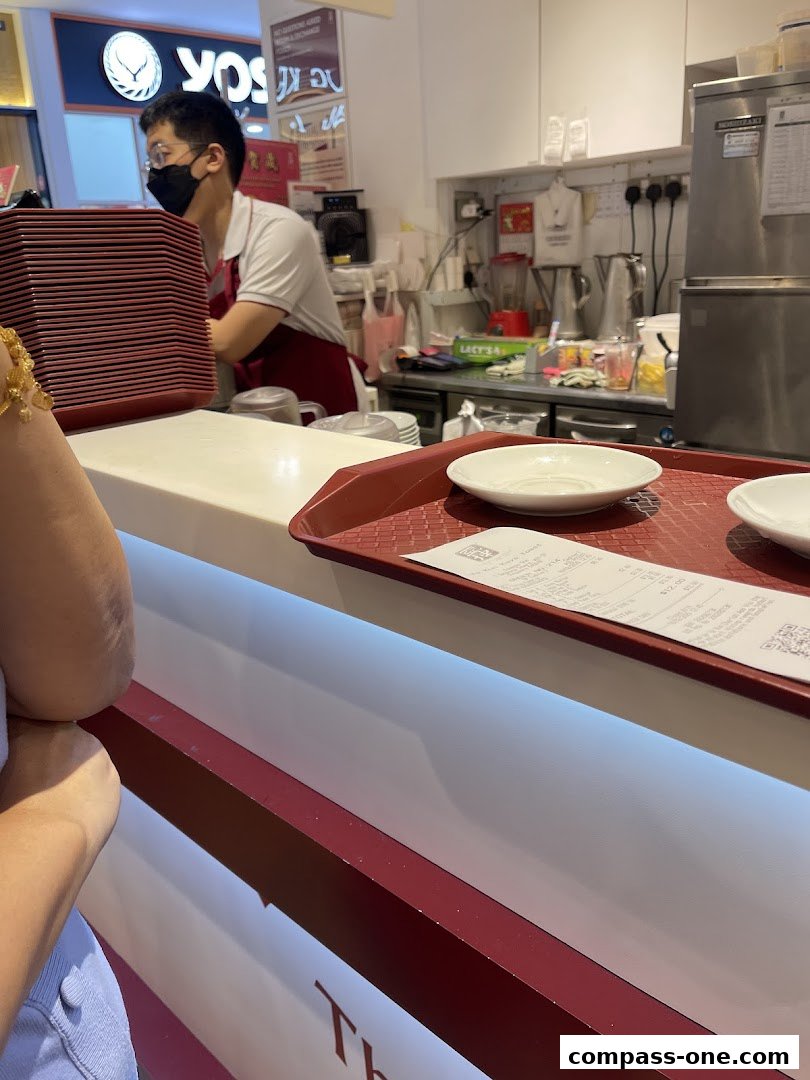 A staff member at Ya Kun Kaya Toast prepares orders behind the counter.