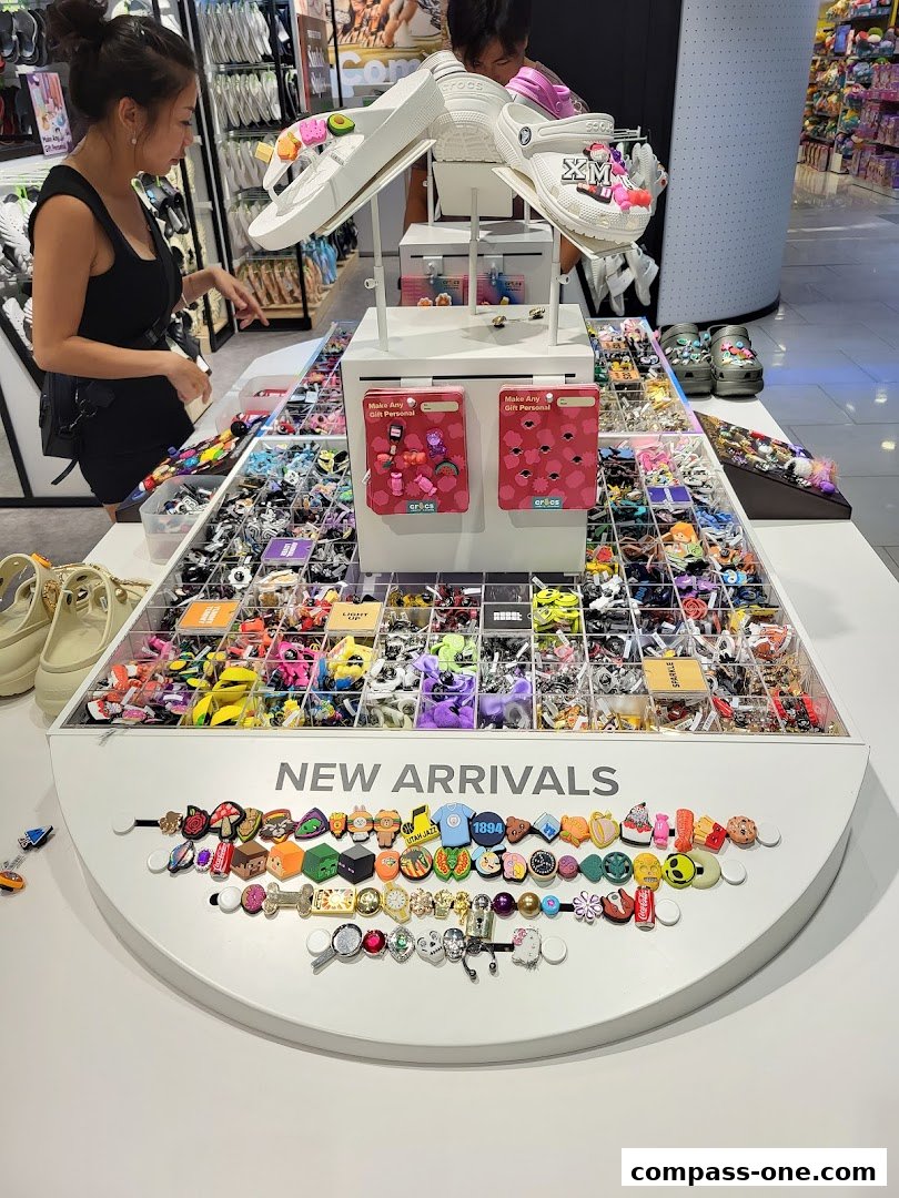 A display of Crocs shoes and a wide variety of Jibbitz charms for customization.