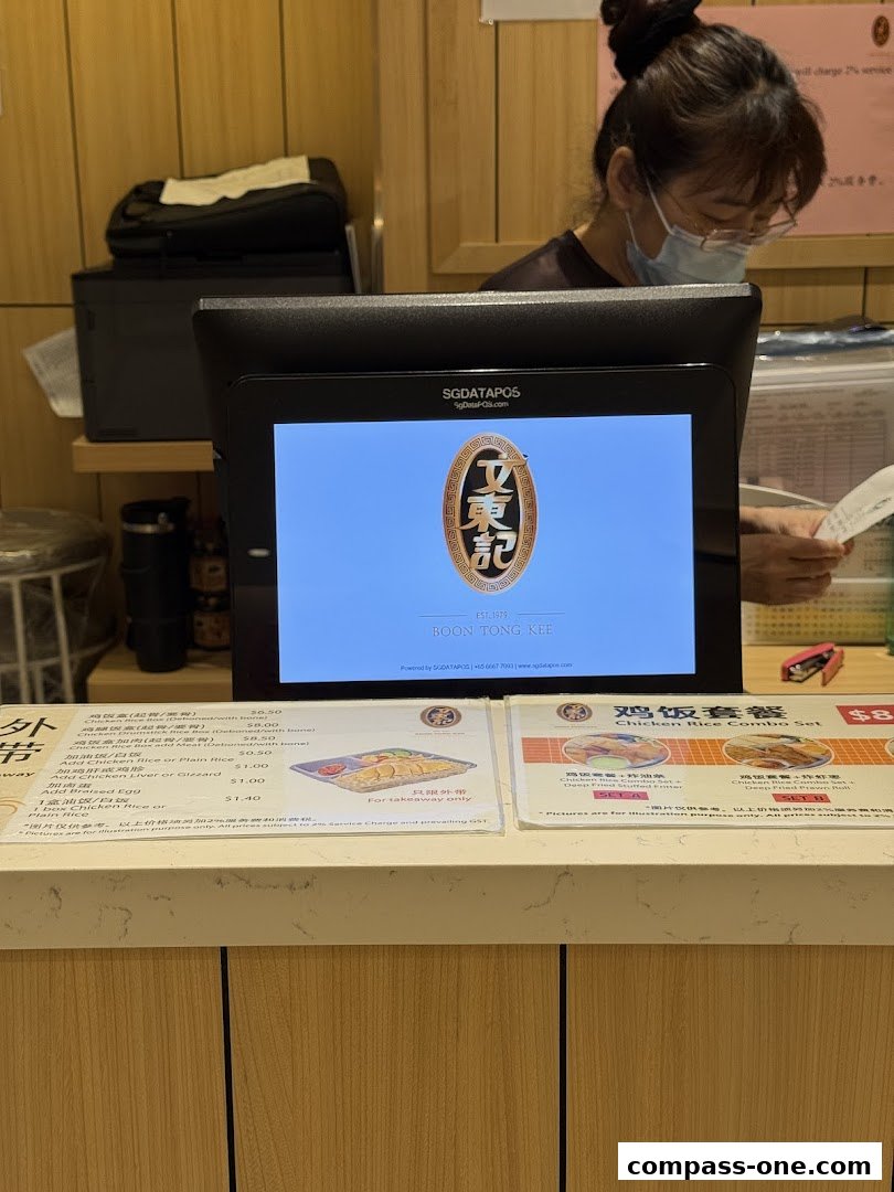 A counter display shows menus and a POS system for Boon Tong Kee restaurant.