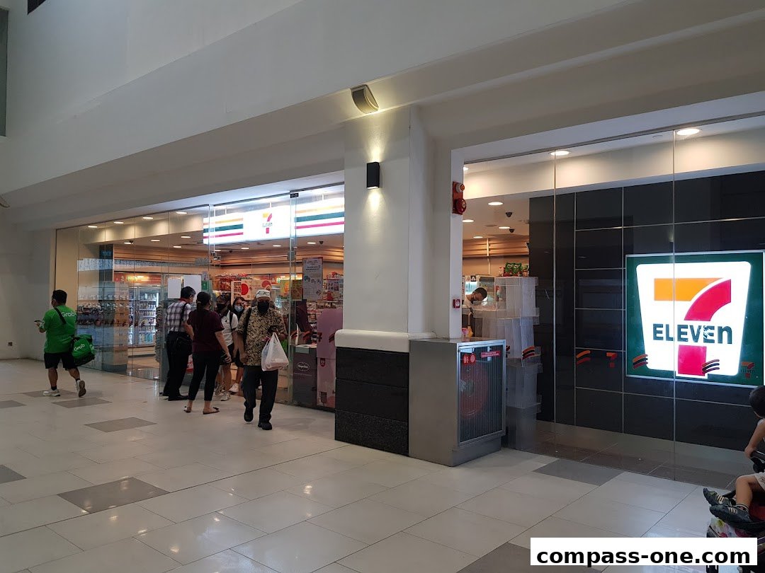 People entering and exiting a brightly lit 7-Eleven convenience store.