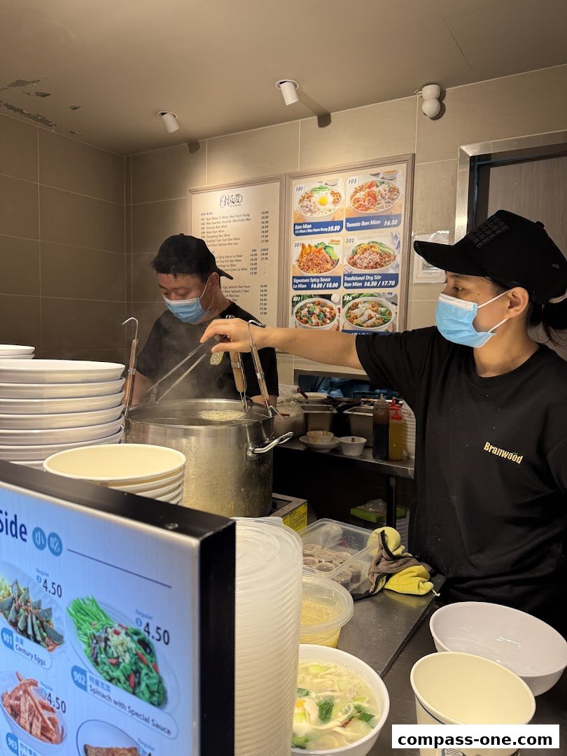 Staff preparing food behind a counter with menus and ingredients visible.