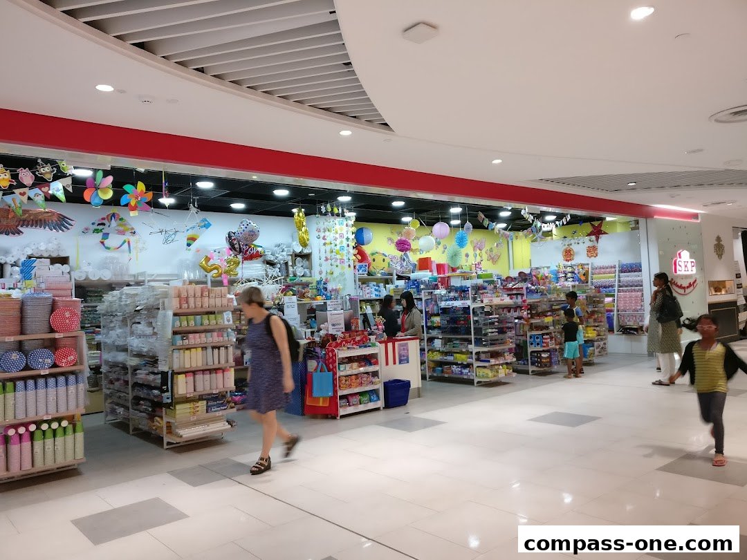 A brightly lit shop interior filled with party supplies, decorations, and various retail items.