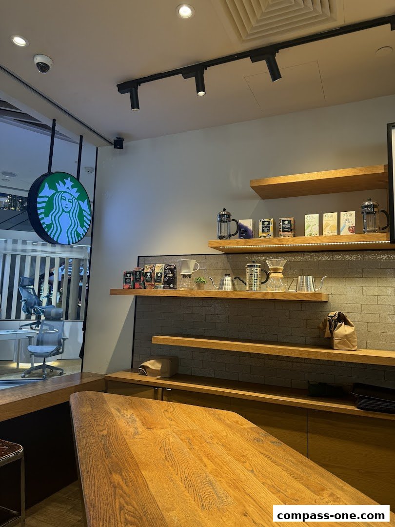 Interior view of a Starbucks coffee shop with a wooden counter and shelves displaying coffee brewing equipment.