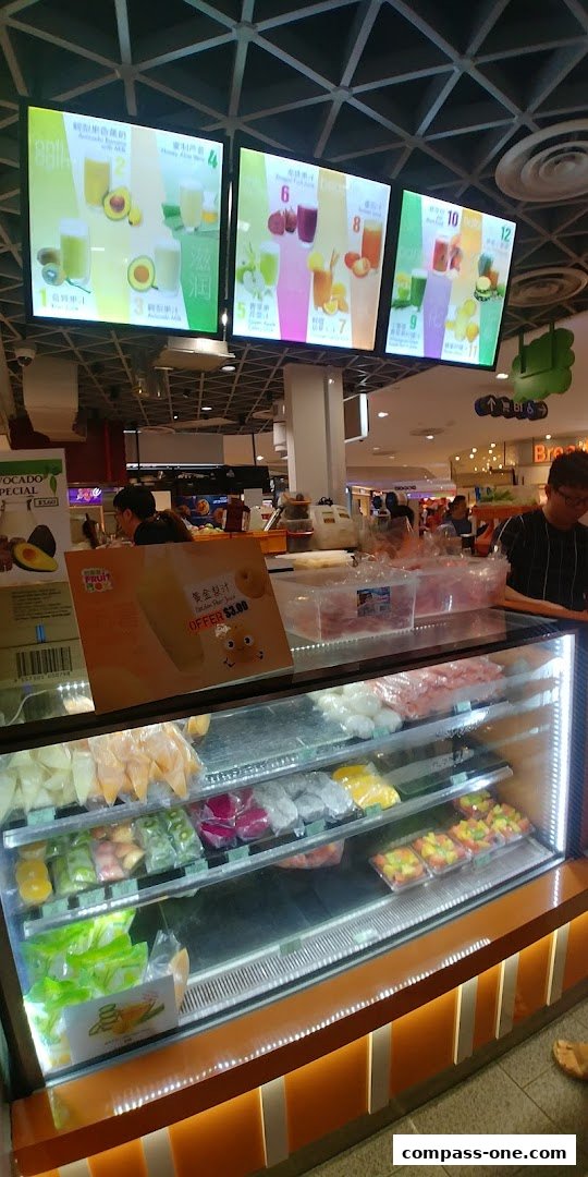 A display case filled with fresh fruits and juices at a shop called Fruit Box.