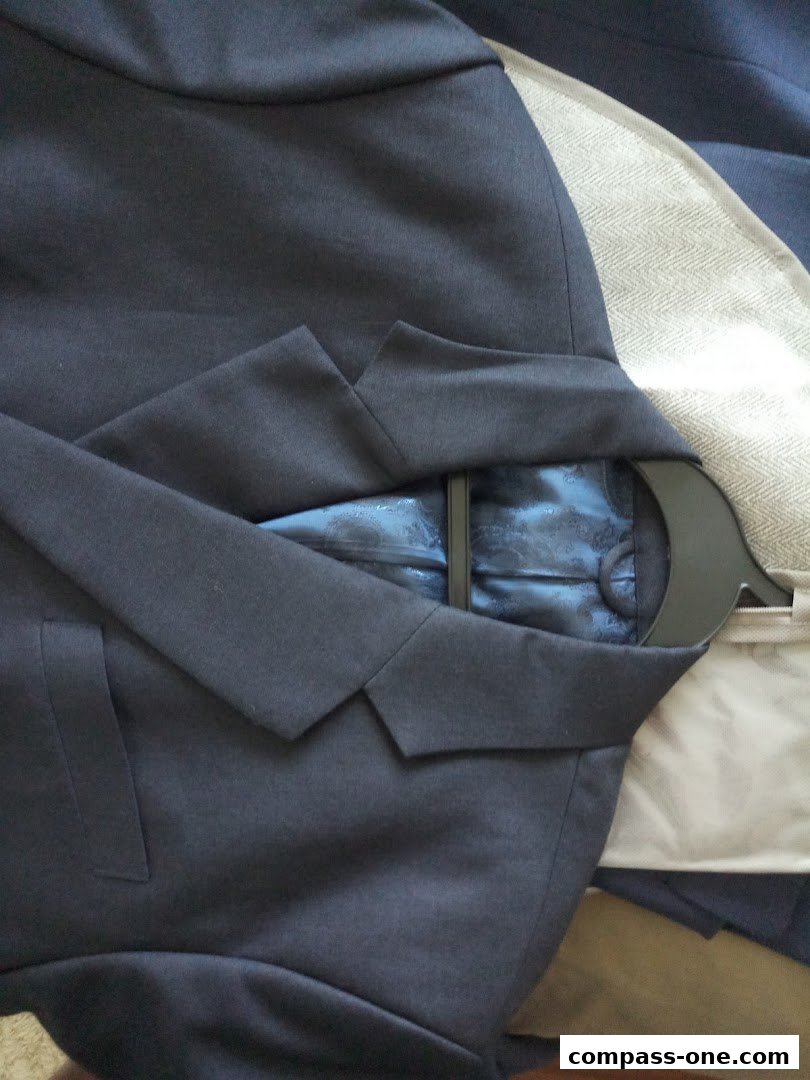 A close-up view of a dark blue suit jacket with a patterned blue lining.