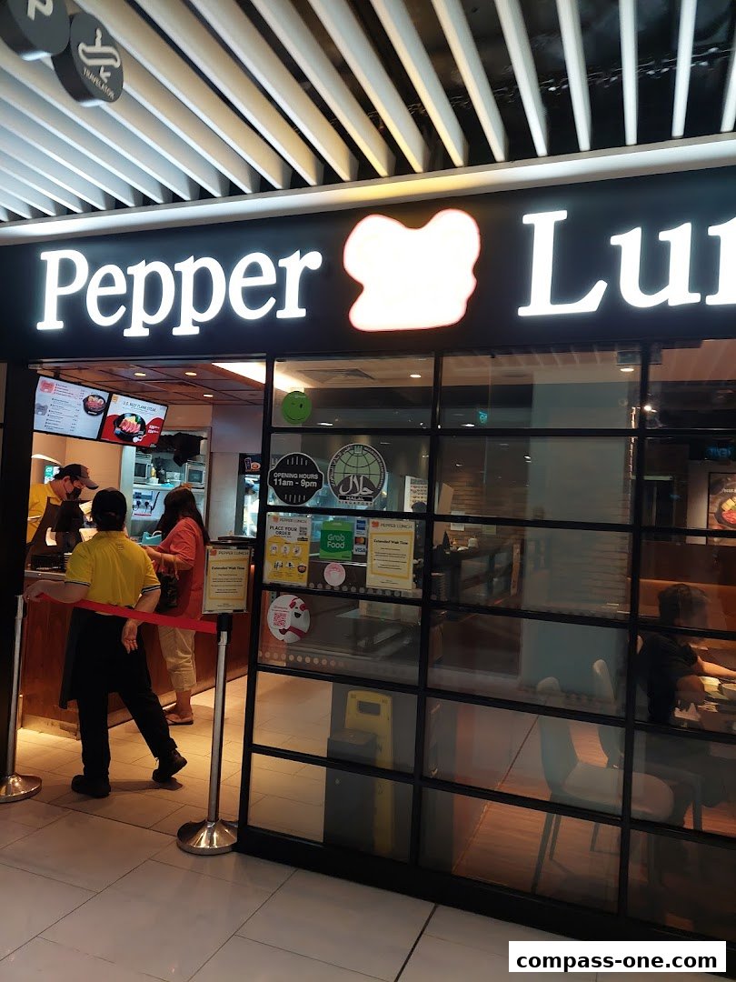 The exterior of a Pepper Lunch restaurant with staff and customers visible inside.
